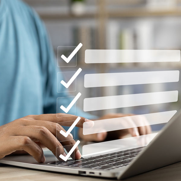  Man focused on a laptop displaying a checklist, indicating task management or productivity in a work environment.