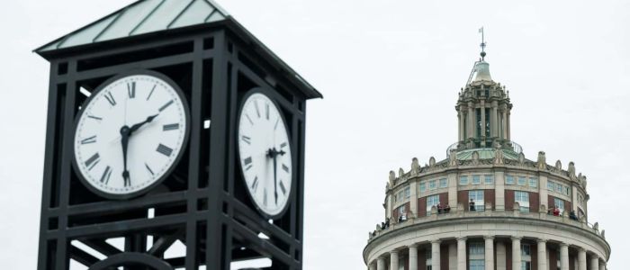 Clock tower and clock-adorned building at the University of Rochester, showcasing architectural elegance and historical significance.