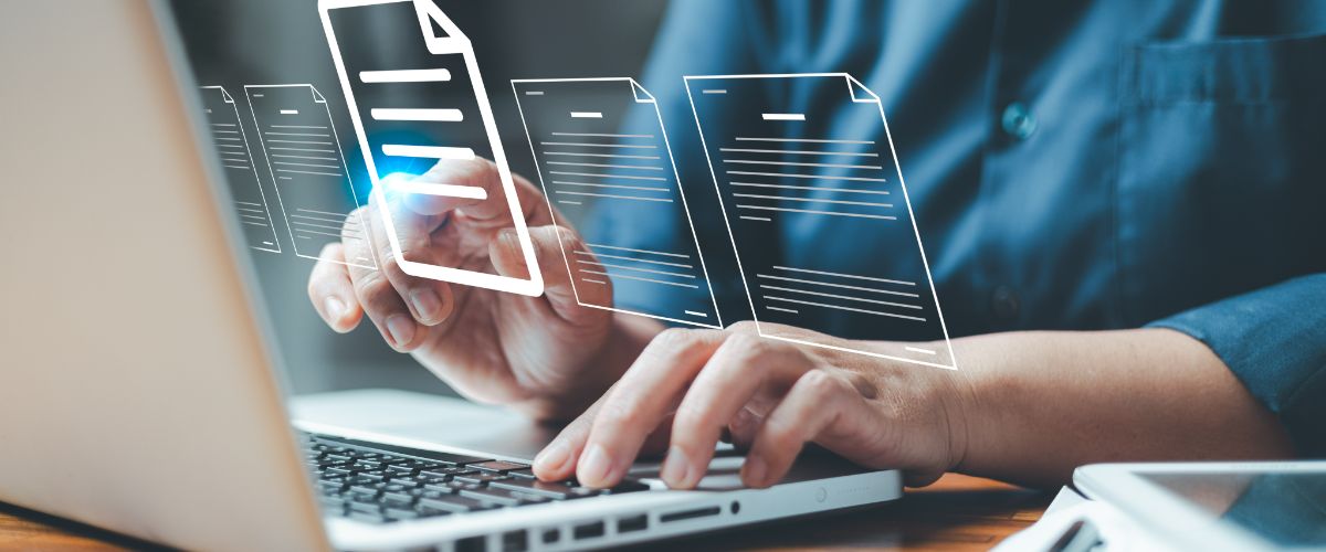 A person typing on a laptop with floating digital document icons above the keyboard.